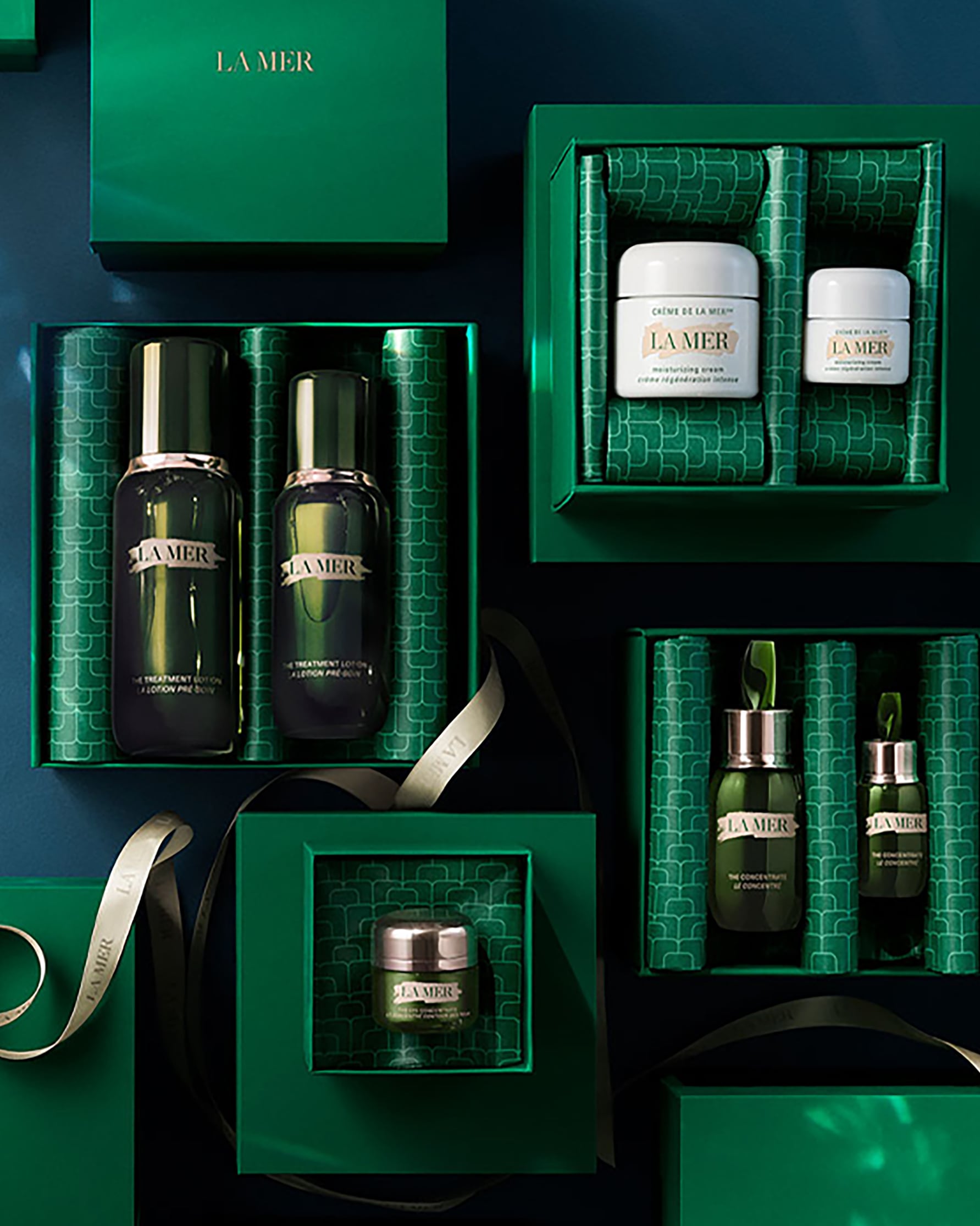 Display of open gift boxes with products inside and ribbon floating inbetween.